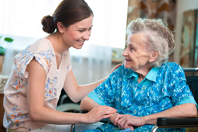 find a good caregiver - young, female helping her elderly loved one sitting in a wheelchair