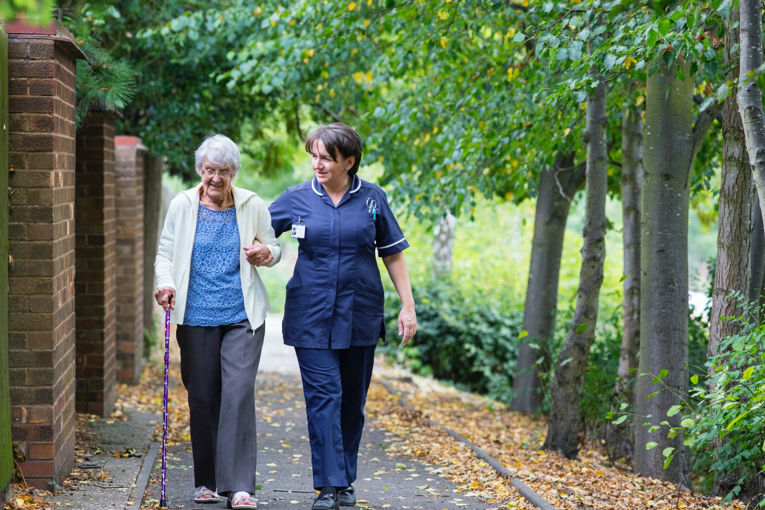 elderly woman and her caregiver going for an outdoor walk