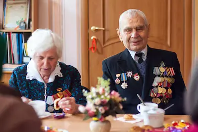 Veteran man in uniform with his wife sitting at a table having coffee