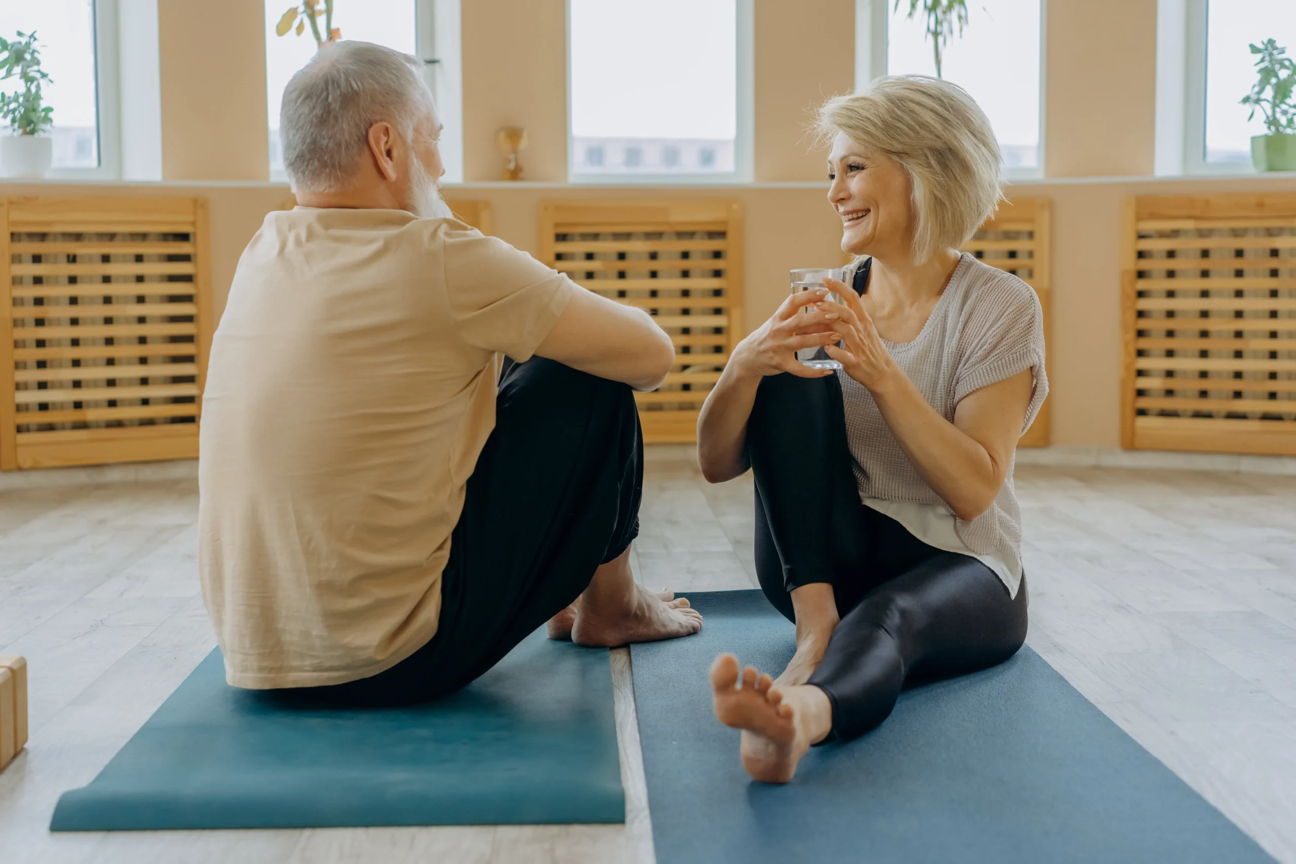 Elderly couple sitting together in yoga room