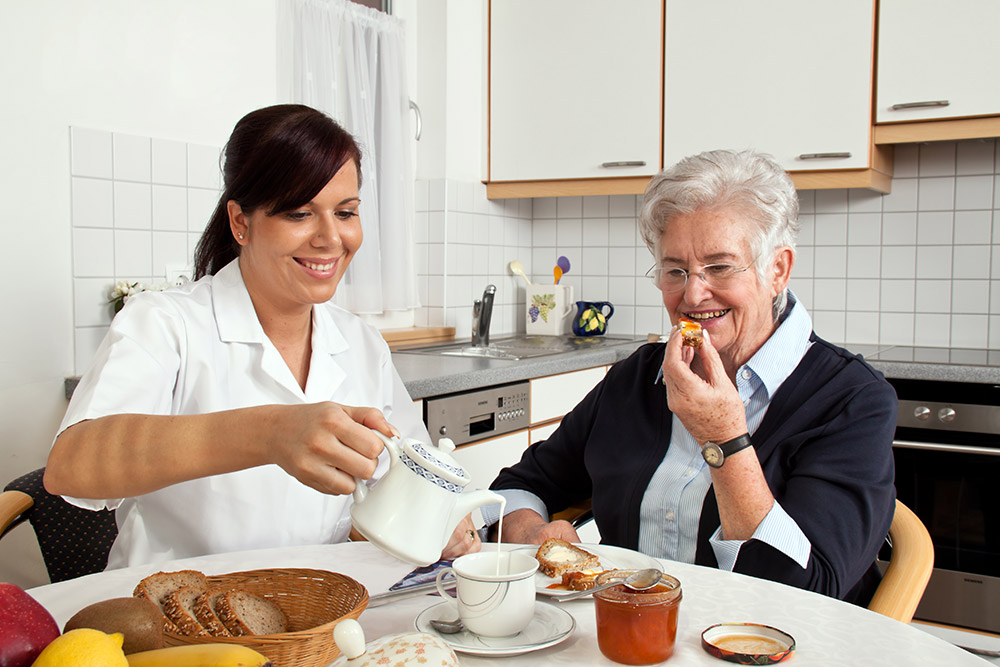 Nursing helping a women with breakfast