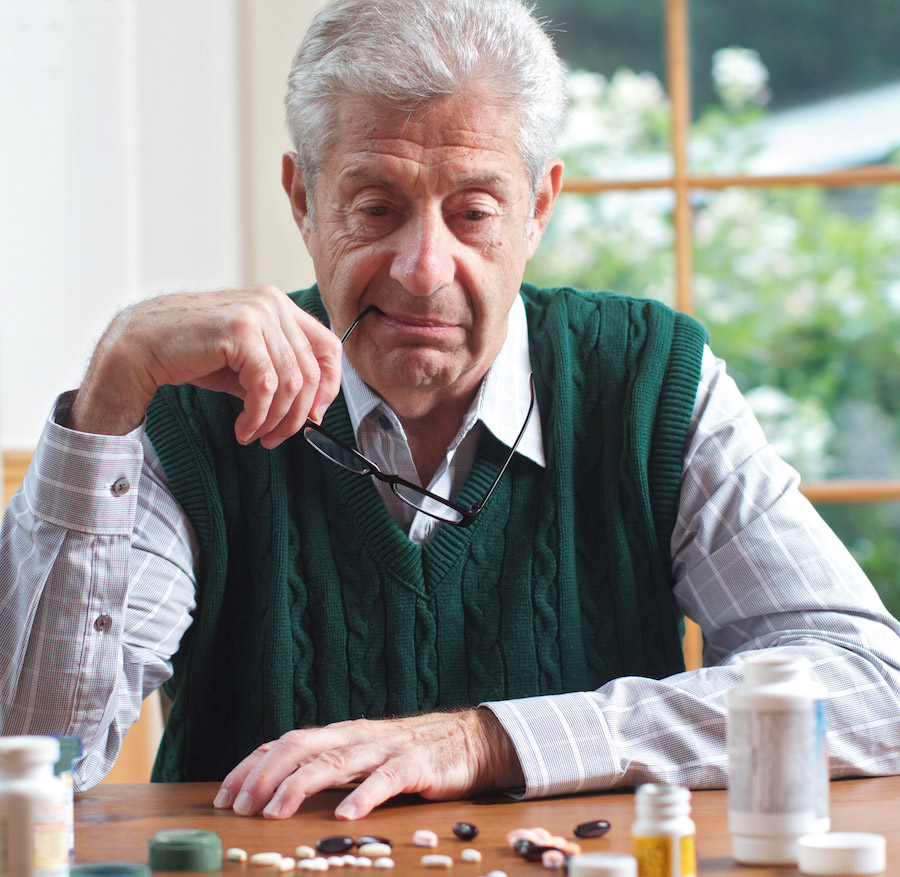 senior looking at his medications