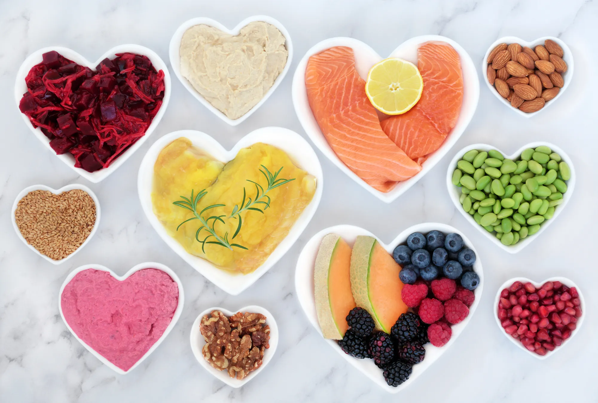 take care of your heart by eating good foods: collection of heart-shaped bowls with heart-healthy foods