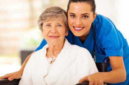 Dementia In Home Care - happy senior woman on wheelchair with caregiver