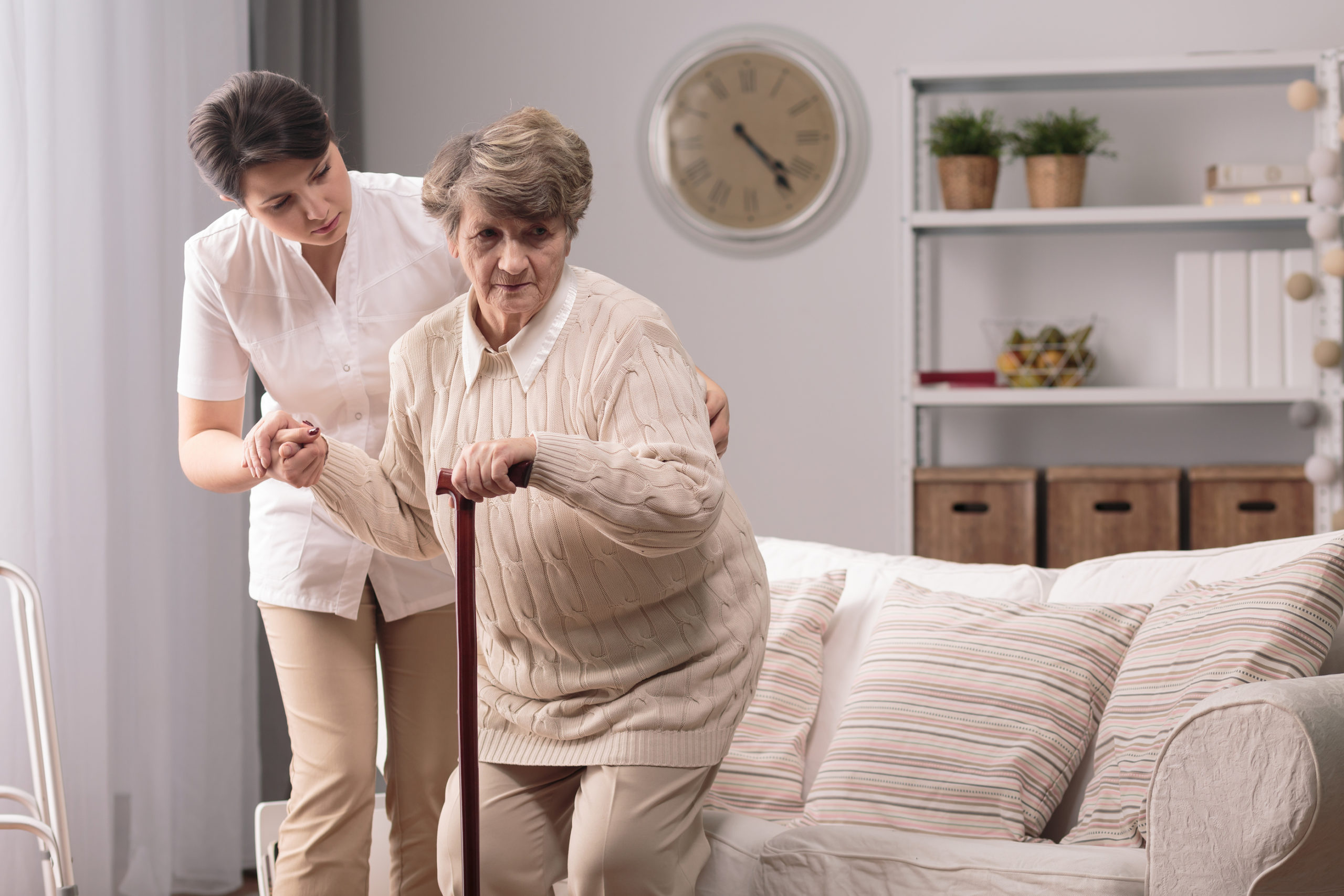 Elderly woman being assisted by caregiver in home