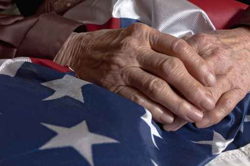 Veterans hands rest on the American flag
