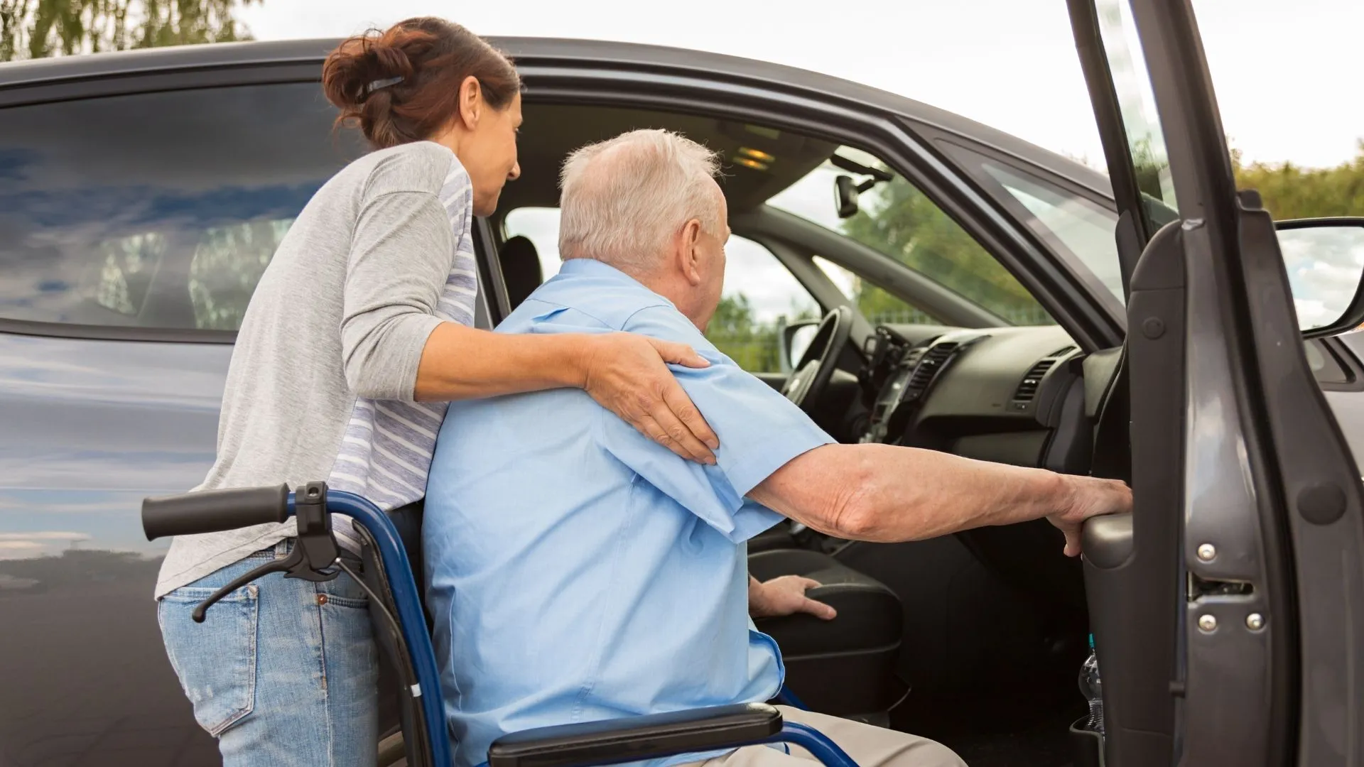caregiver helping man into car