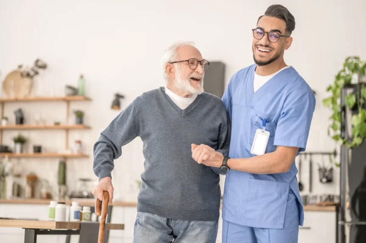 professional caregiver helping senior man walk with cane