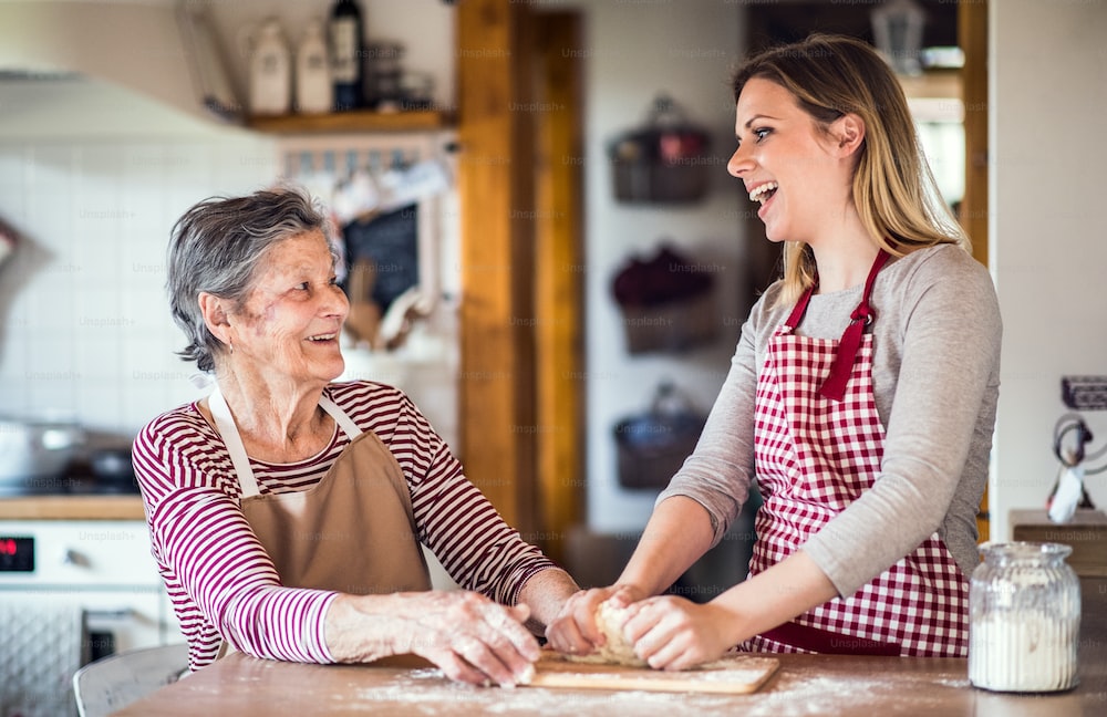 granddaughter baking with her elderly grandmother