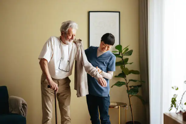 knee replacement recovery at home, caregiver helping elderly man with a walker