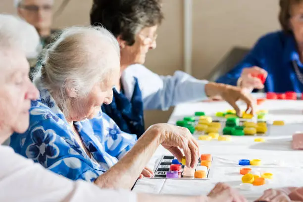 memory games for seniors, group of elderly playing bingo cards