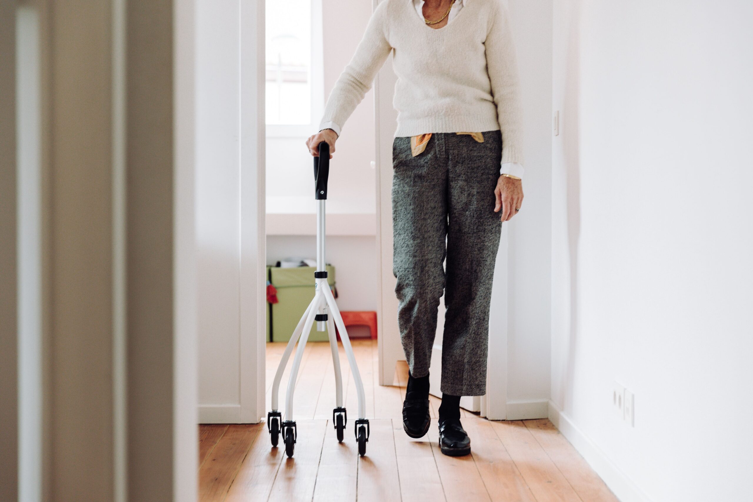 knee replacement recovery at home, elderly woman using a walker after knee surgery